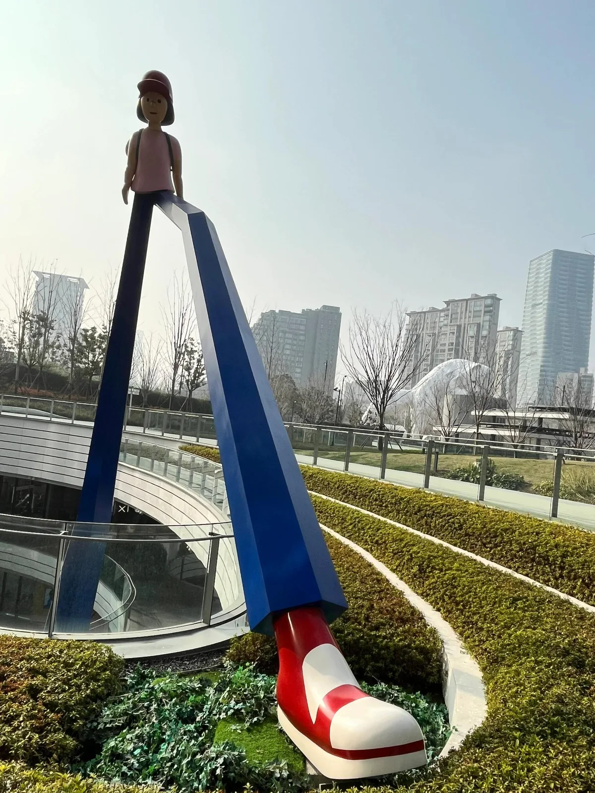 Tall commercial atrium artwork viewed across an upper terrace and lower floor